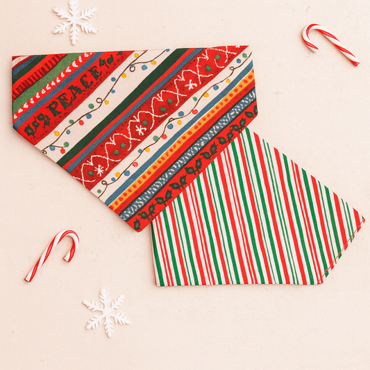 Reversible over-the-collar Christmas dog bandana with peppermint stripes and coordinating holiday reverse, displayed flat on a gray background.